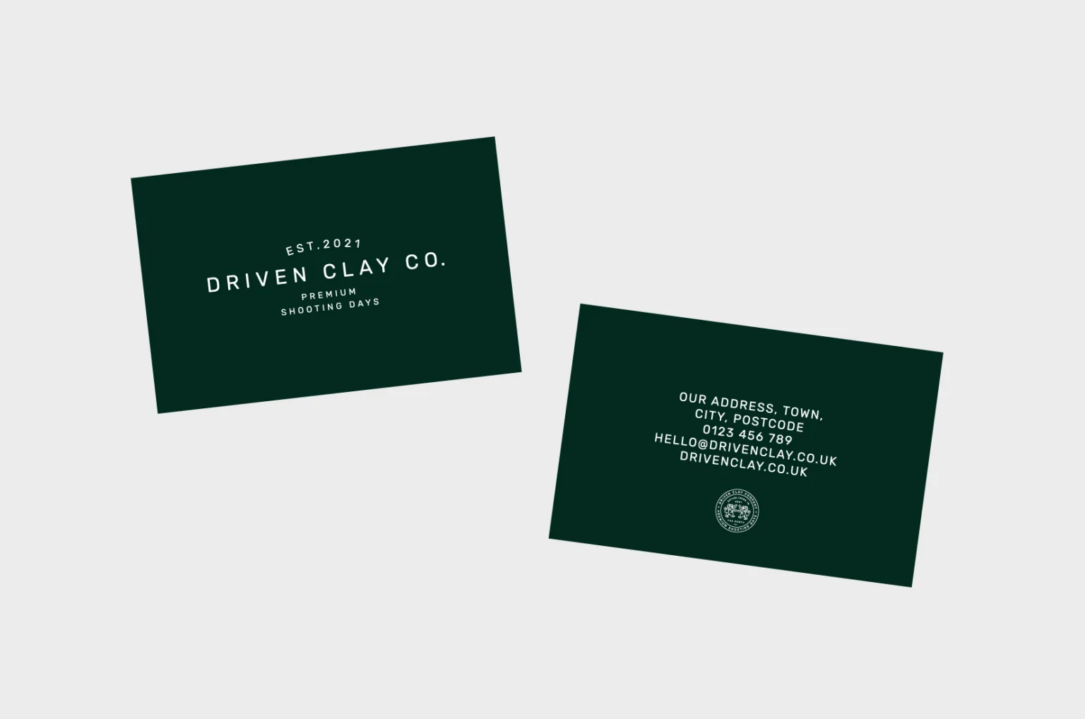 Driven Clay Co. business cards in forest green: wordmark on the front, contact details and crest badge on the back