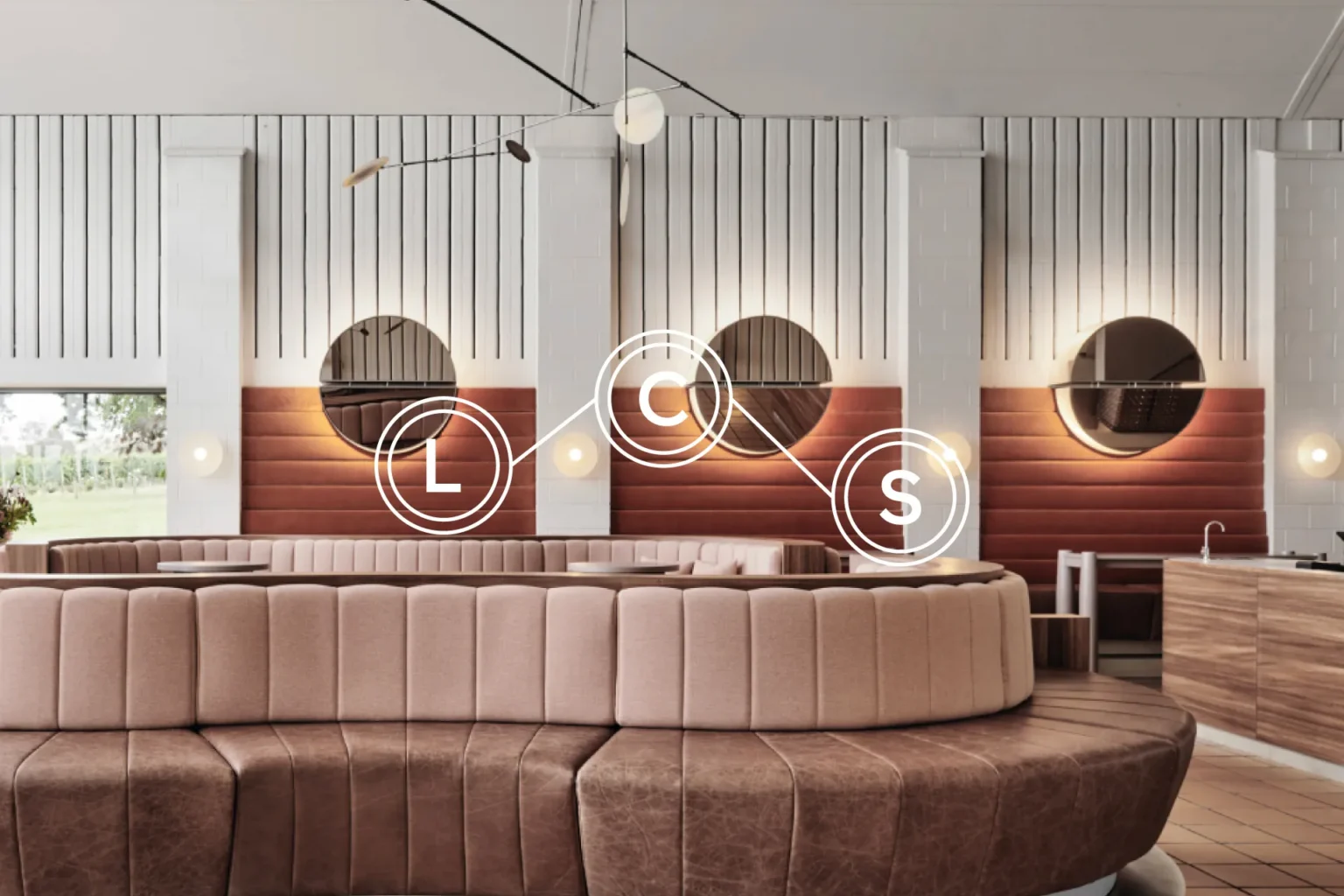 Laser Construction LCS monogram overlaid on a dining interior with a curved leather banquette and round mirrors