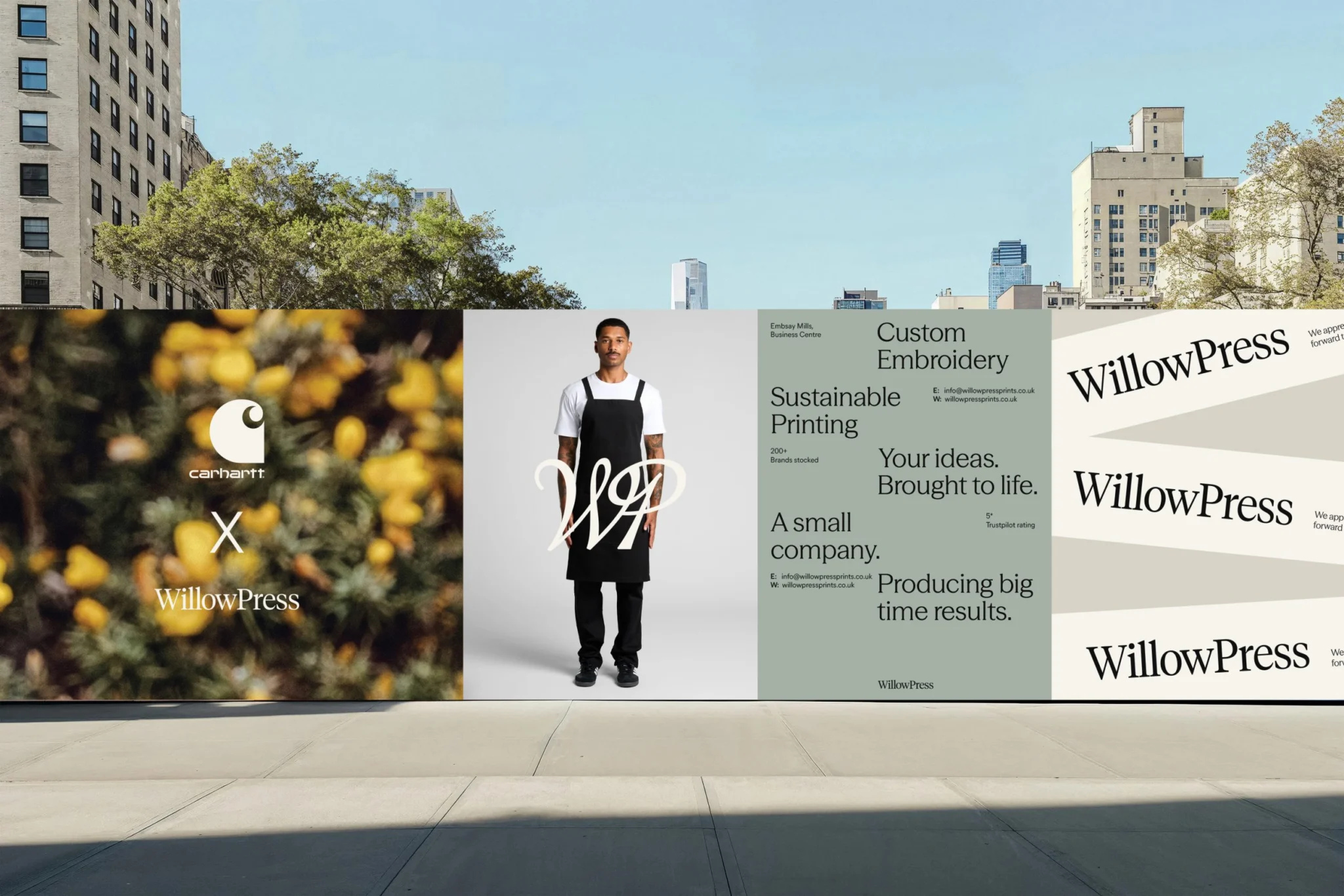 WillowPress street hoarding: Carhartt collaboration, apron model with WP monogram, service messaging and wordmark banners